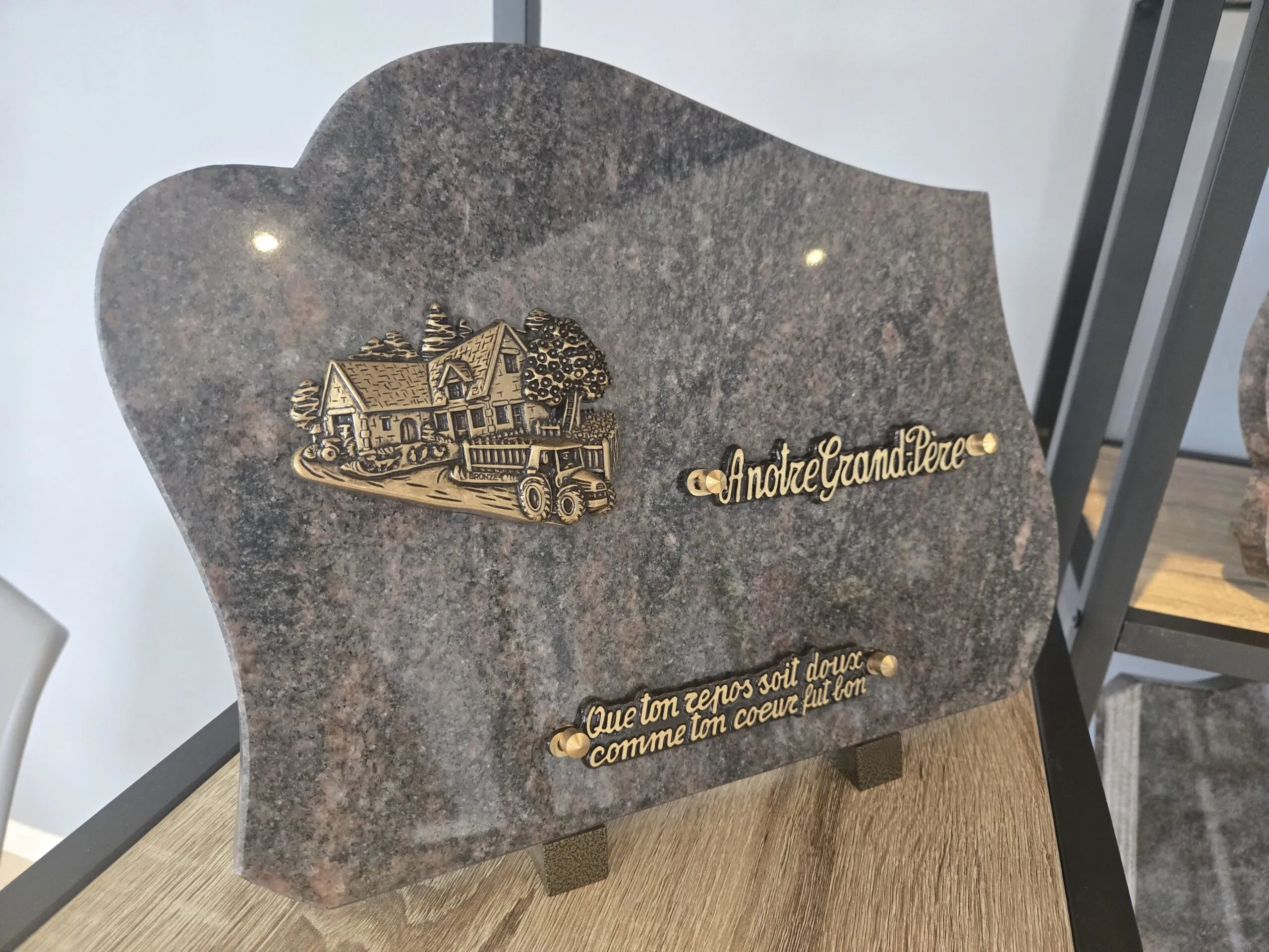 Plaque funéraire en granite rose avec motifs en bronze