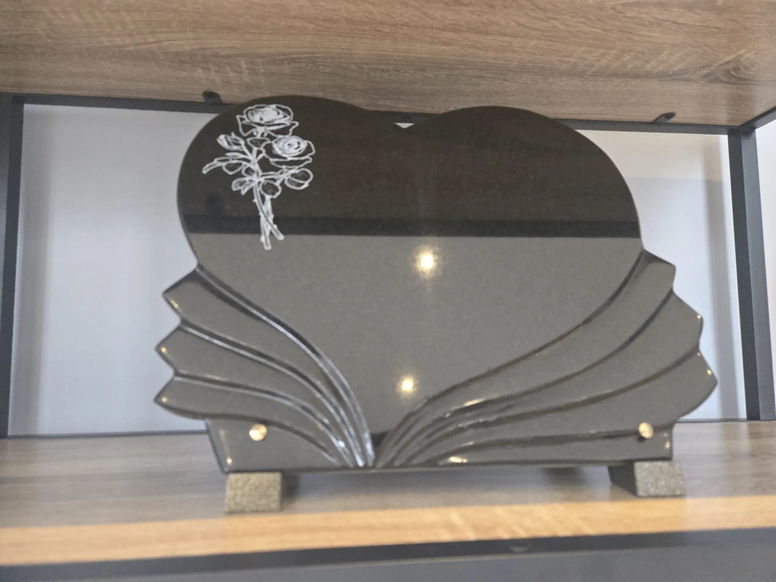 Plaque mortuaire en granite noir découpée en cœur et motifs de roses gravées