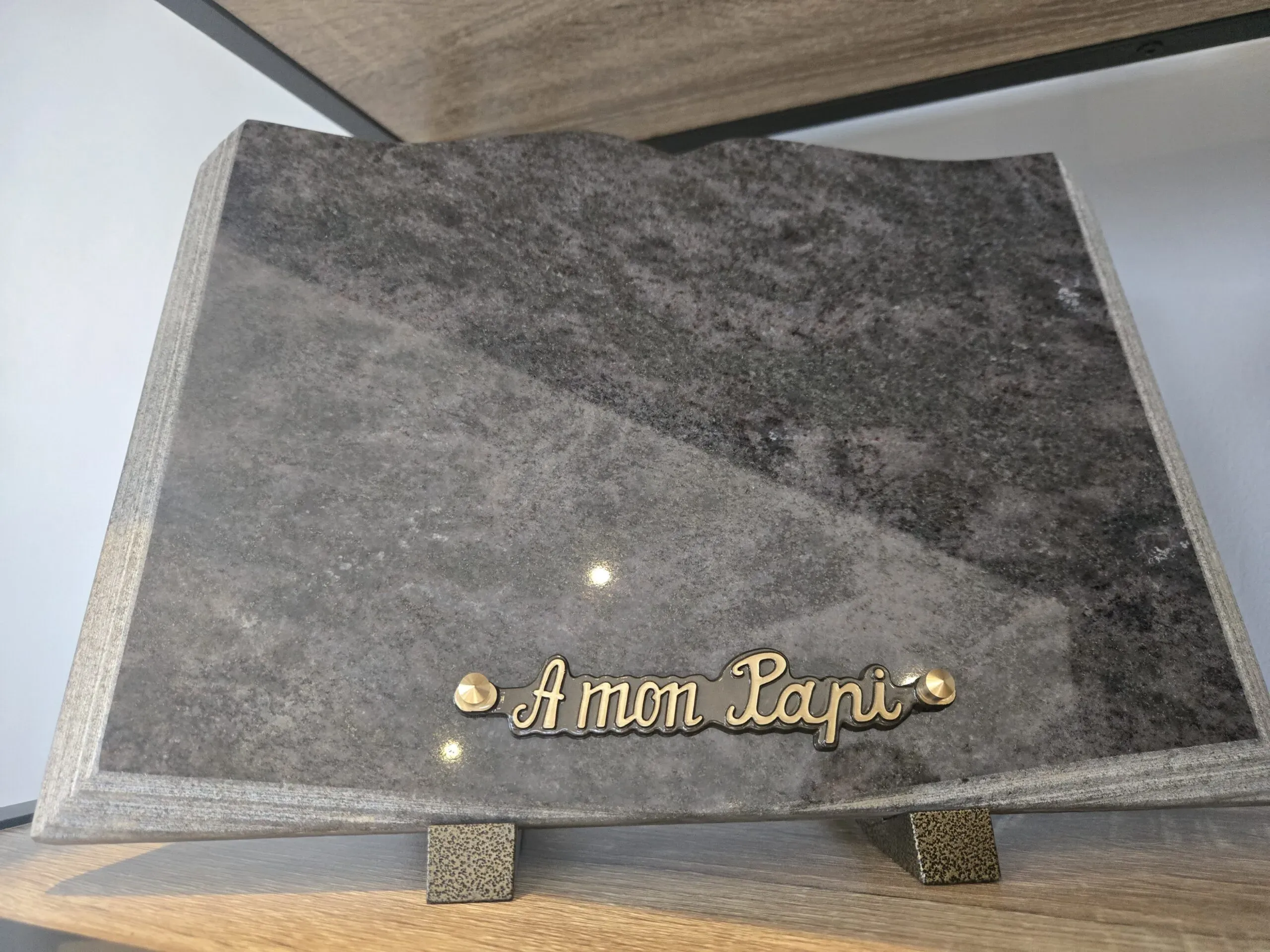 Plaque funéraire rectangulaire en pierre poli marbrée avec texte en relief