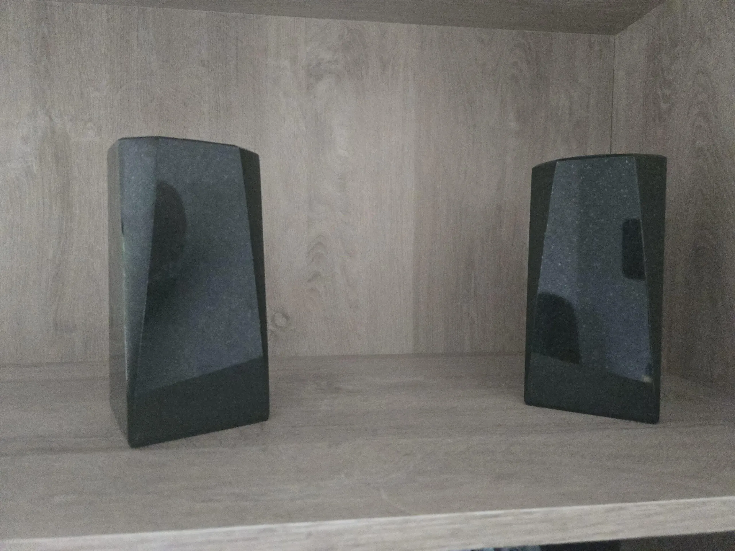 Deux vases funéraires au design géométrique moderne en granite noir poli.